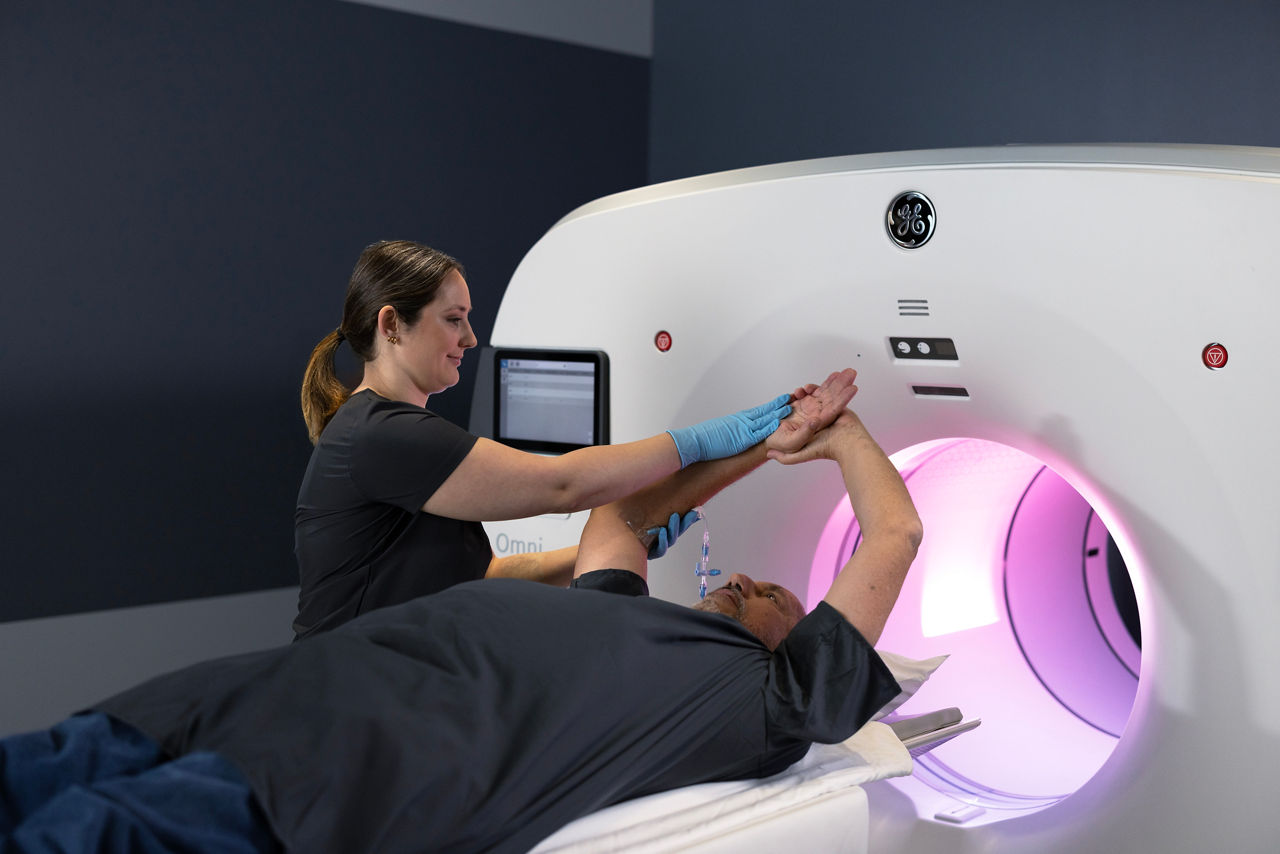 A healthcare professional supporting a patient during an MRI scan
